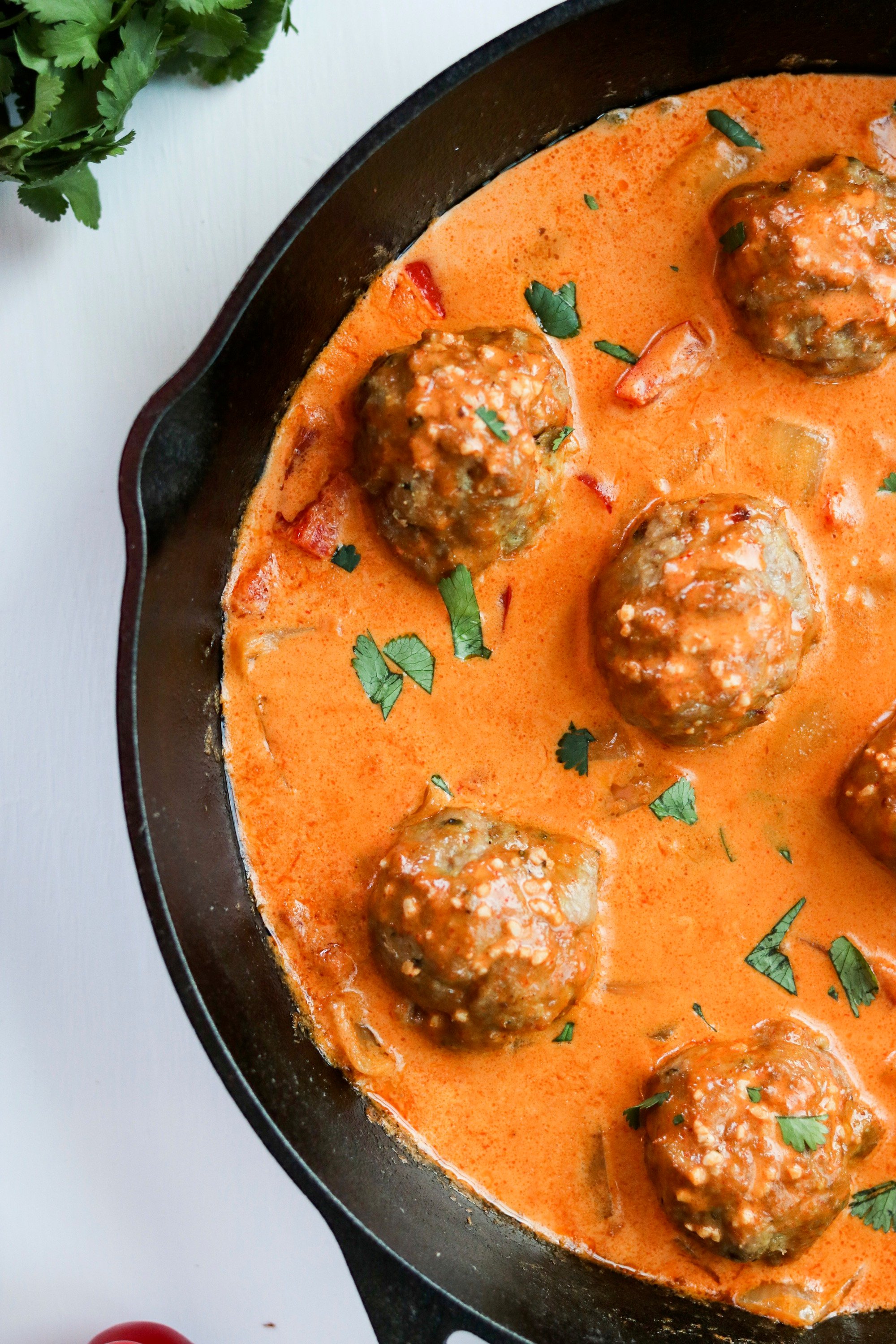 coconut curry turkey meatballs in a cast iron skillet with cilantro