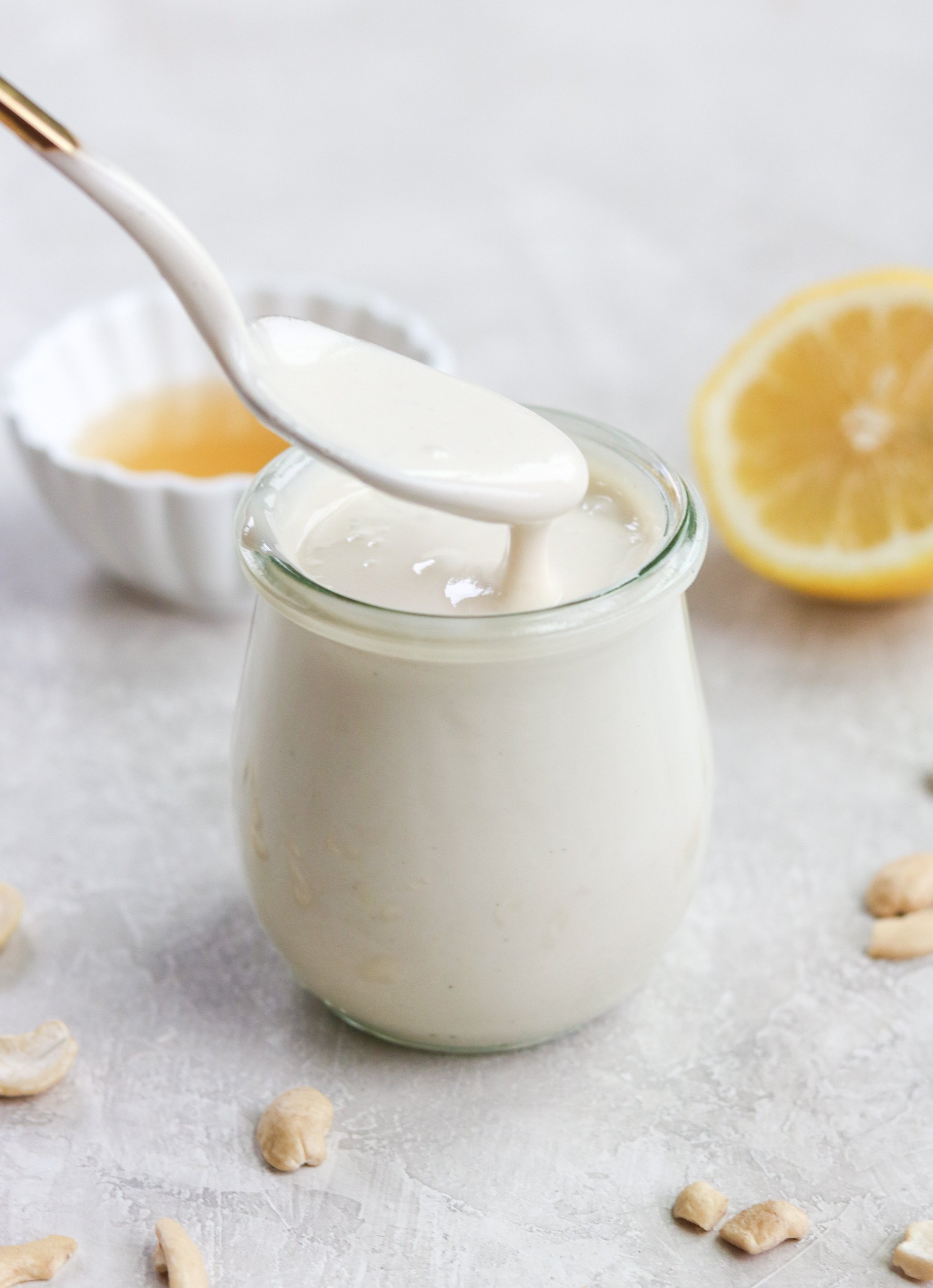 gold spoon lifting some dairy free sour cream out of a jar