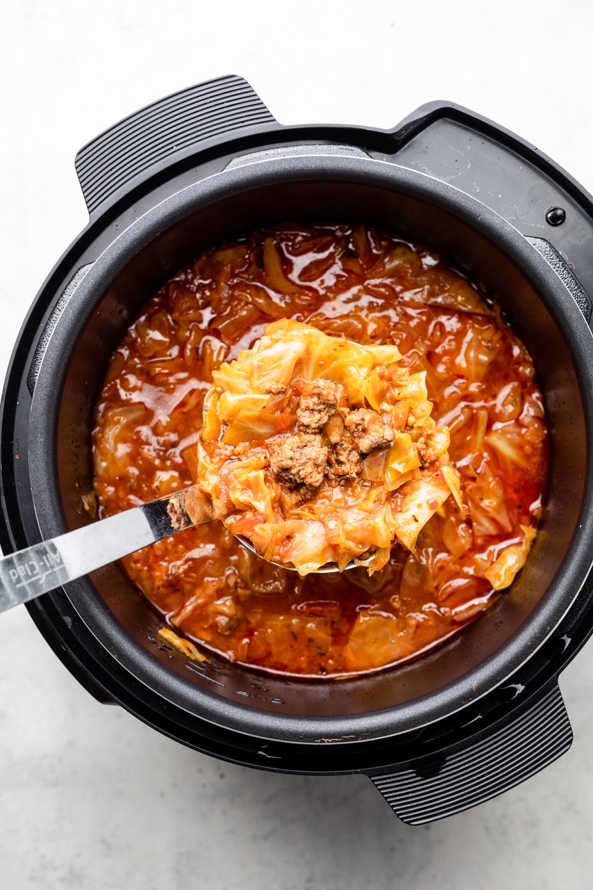 Instant Pot filled with unstuffed cabbage soup with a ladle
