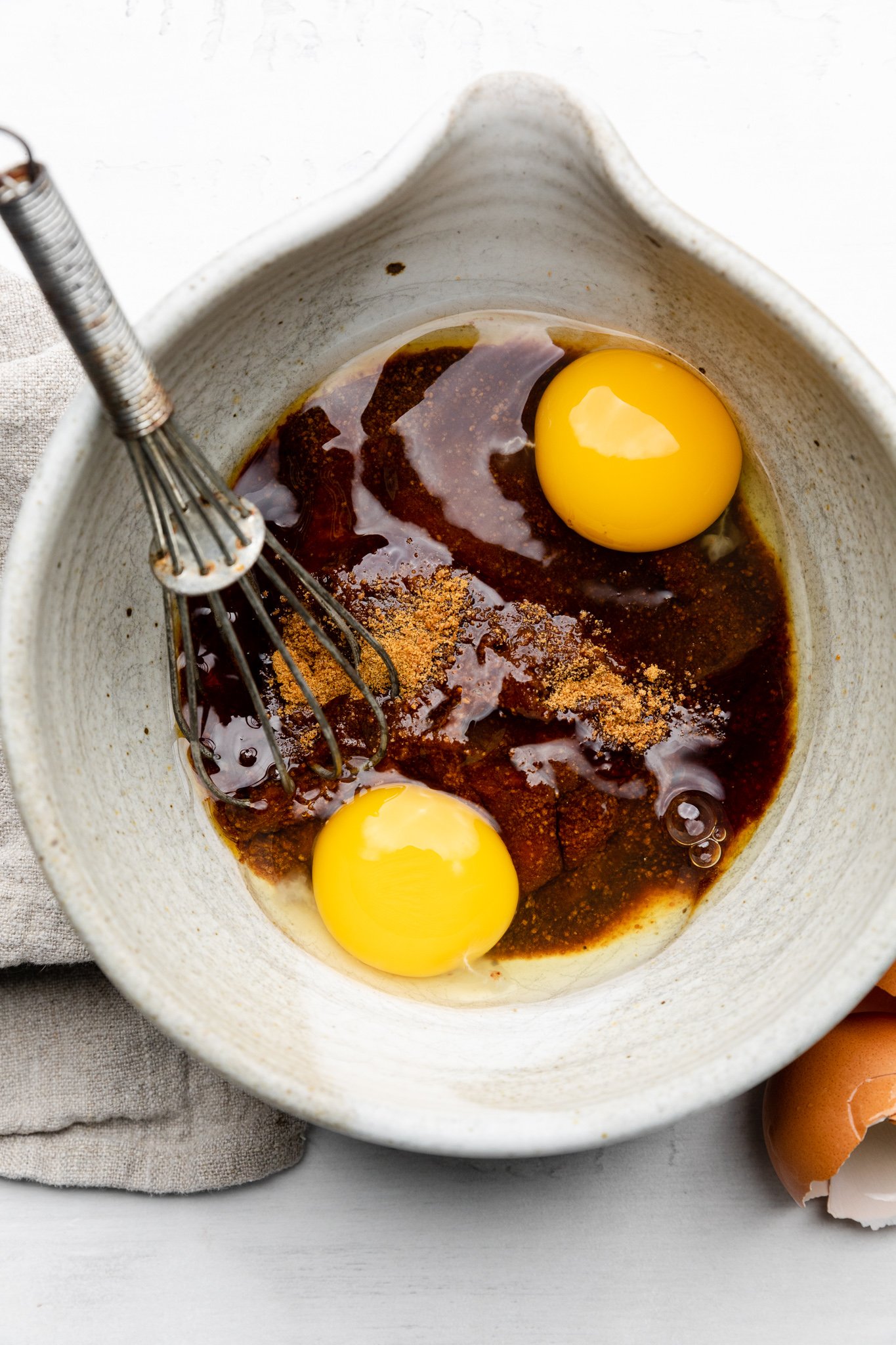 eggs, maple syrup, coconut sugar, and vanilla in a mixing bowl with a whisk