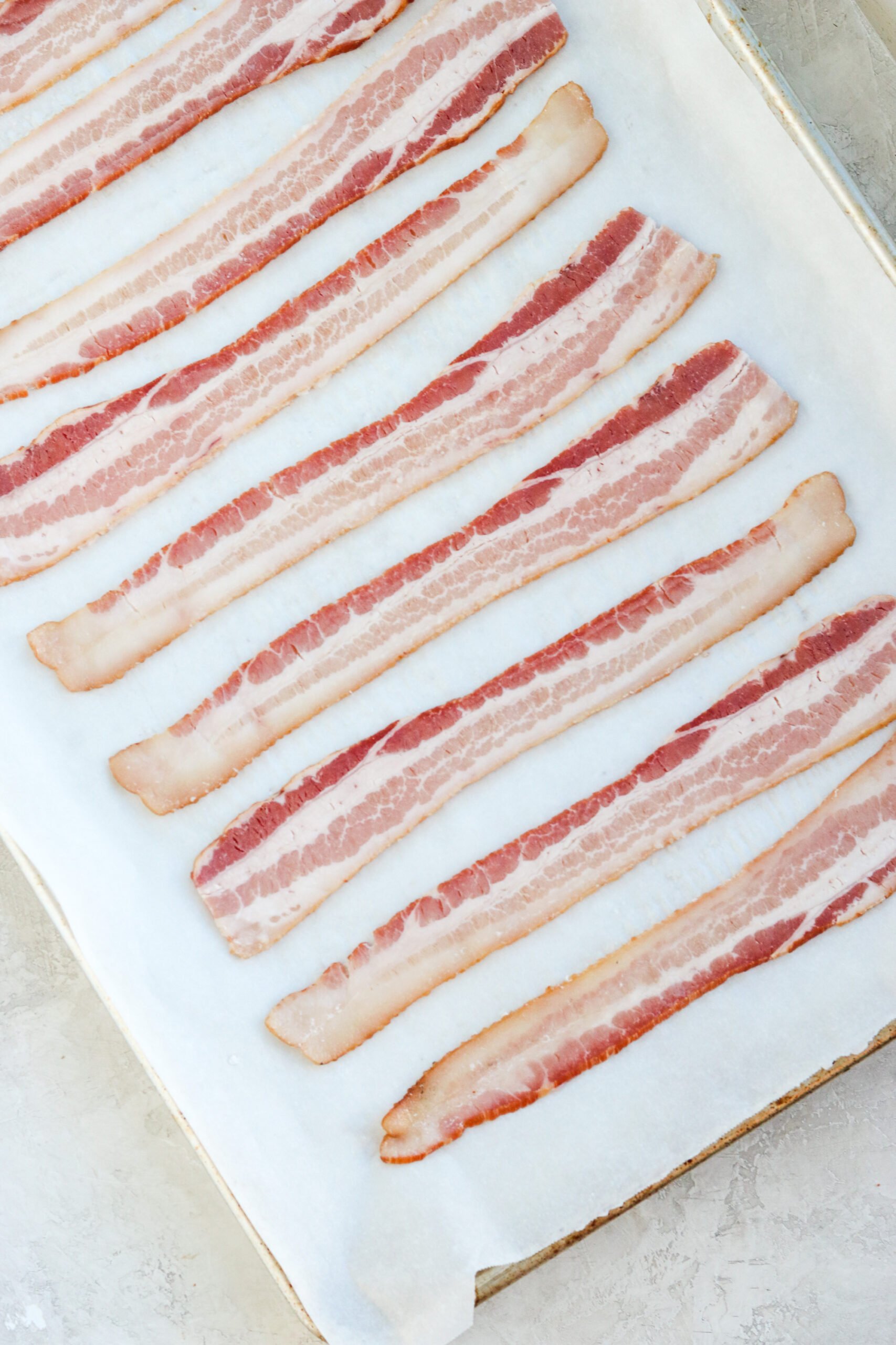 strips of bacon on a parchment paper lined baking sheet