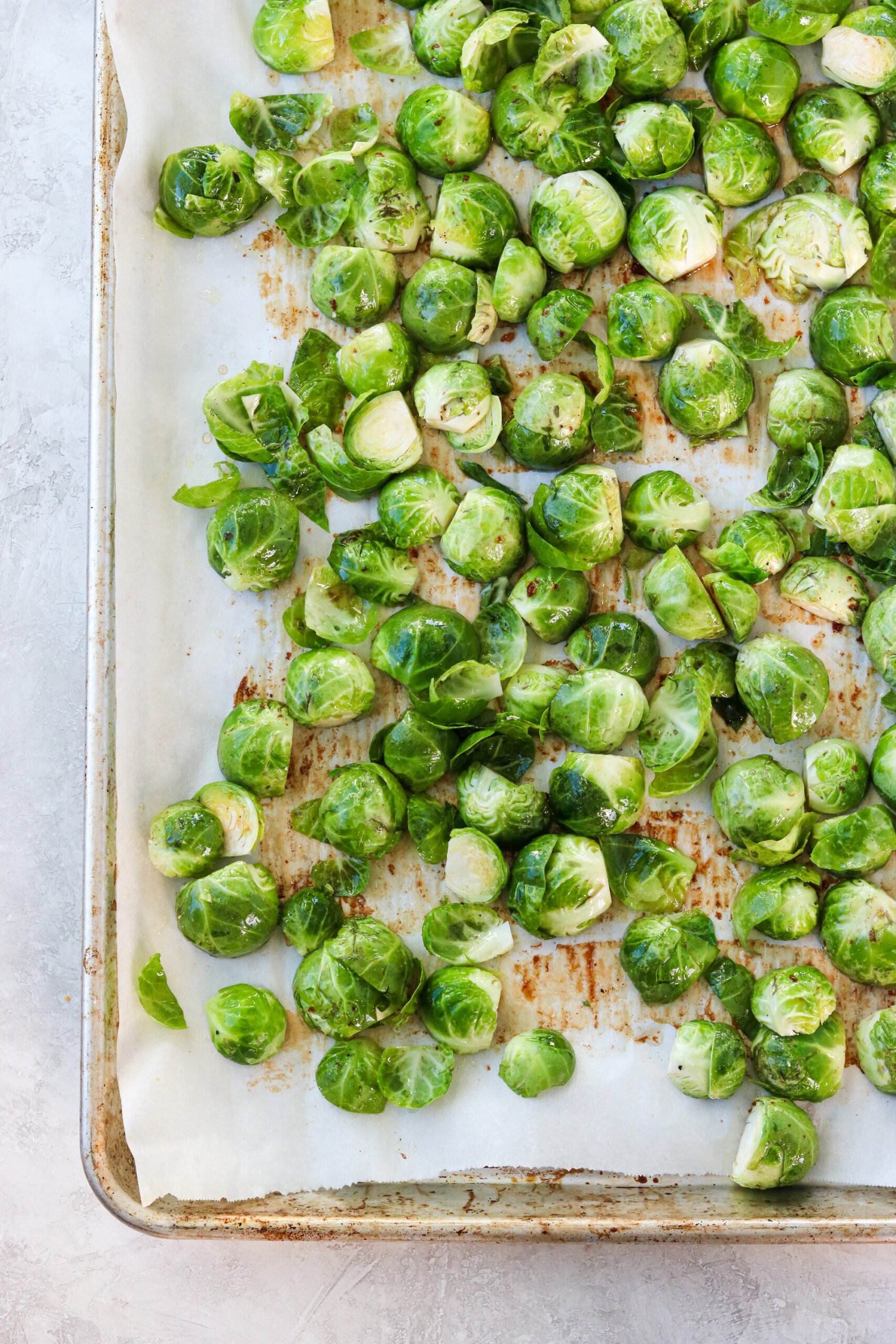 brussel sprouts covered in bacon fat on a parchment paper line baking sheet