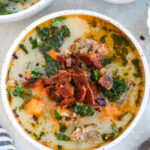 Whole30 Zuppa Toscana in a white bowl topped with bacon and parsley