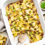 Sausage Hash brown casserole with green onions sliced in a white Staub casserole dish