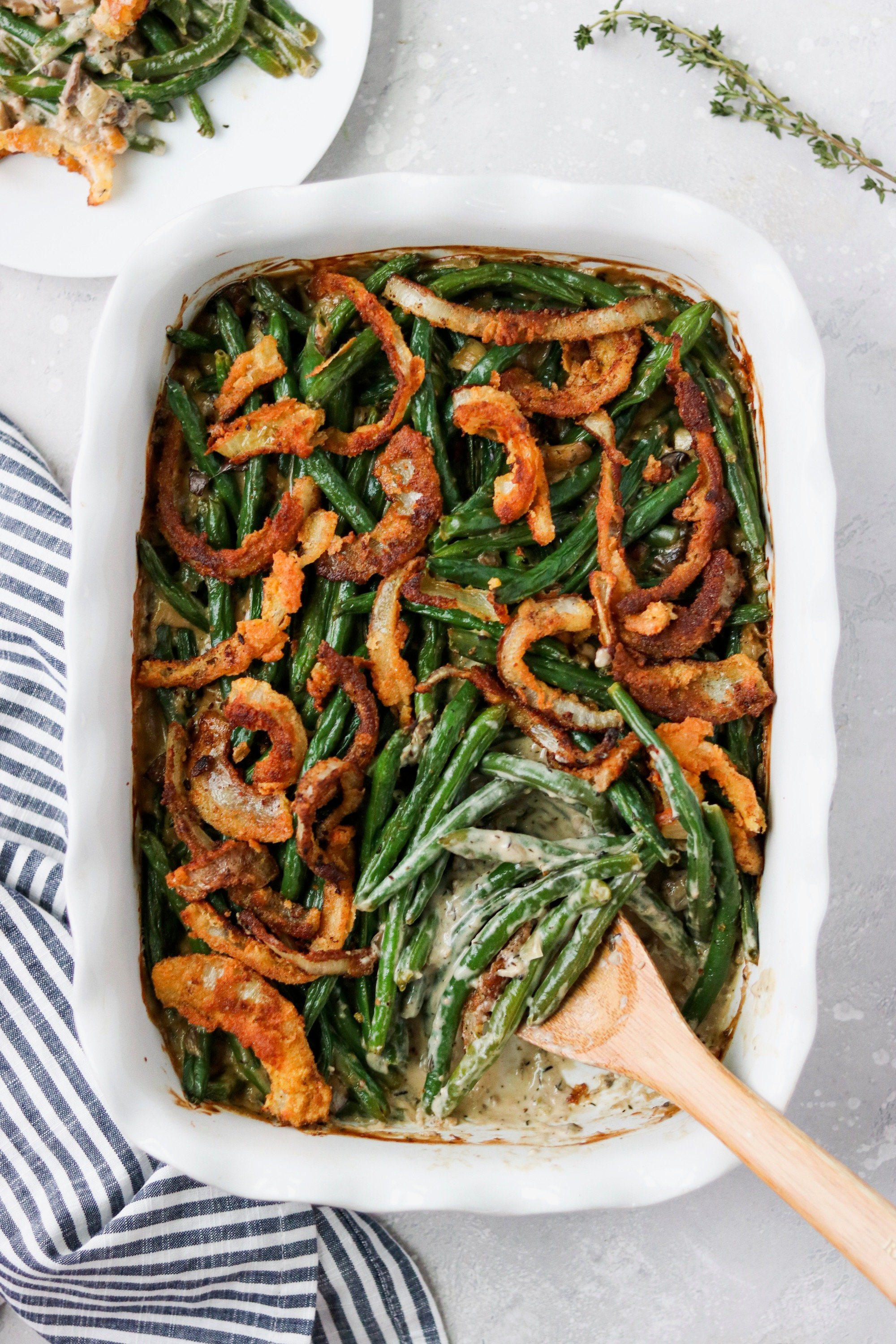 keto green bean casserole topped with homemade french fried onions in a white baking dish