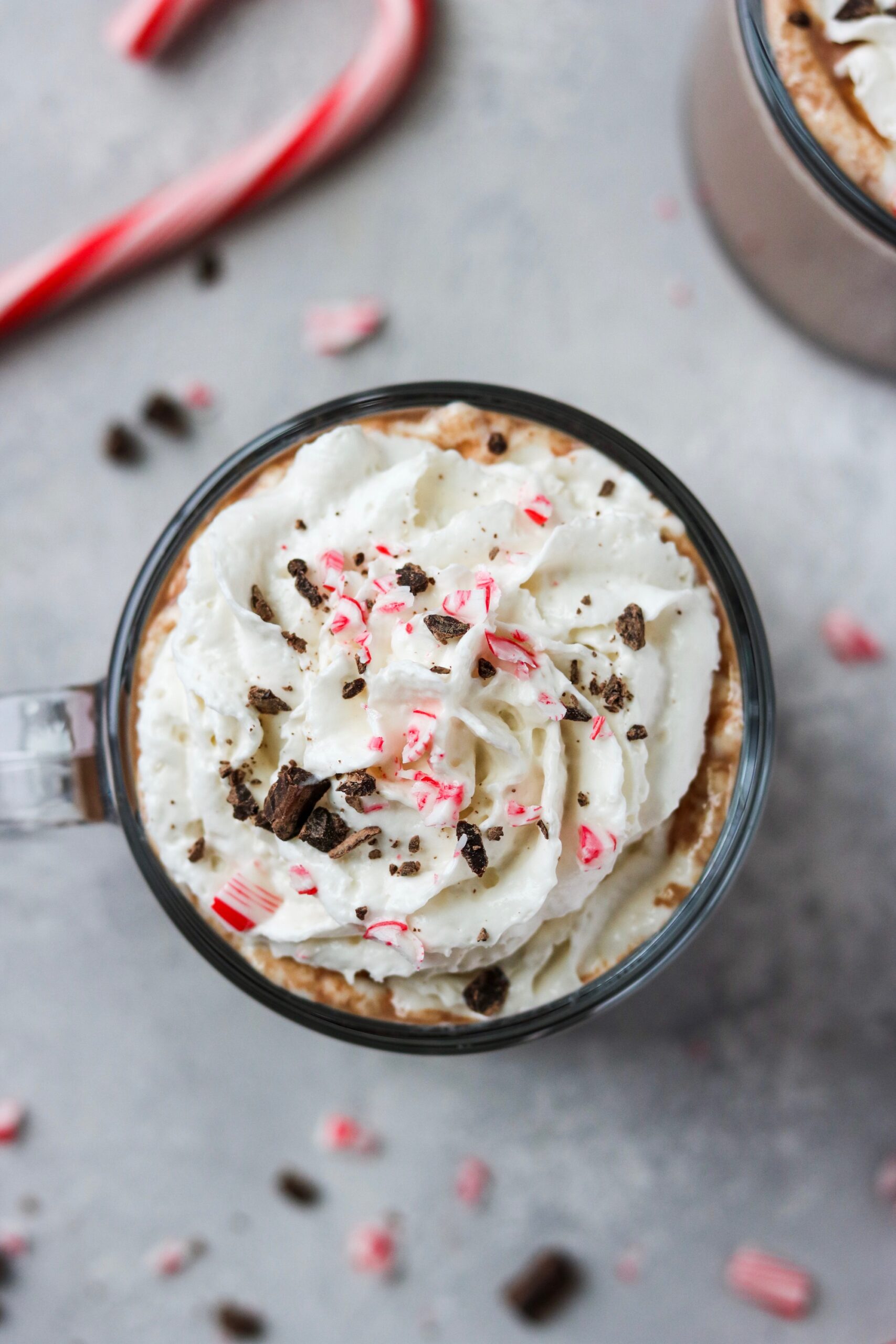 an overhead view of Christmas hot chocolate with whipped cream, peppermint and chocolate crumbles