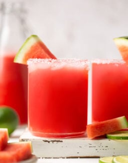a fresh watermelon margarita in a salt-rimmed glass with a wedge of watermelon for garnish
