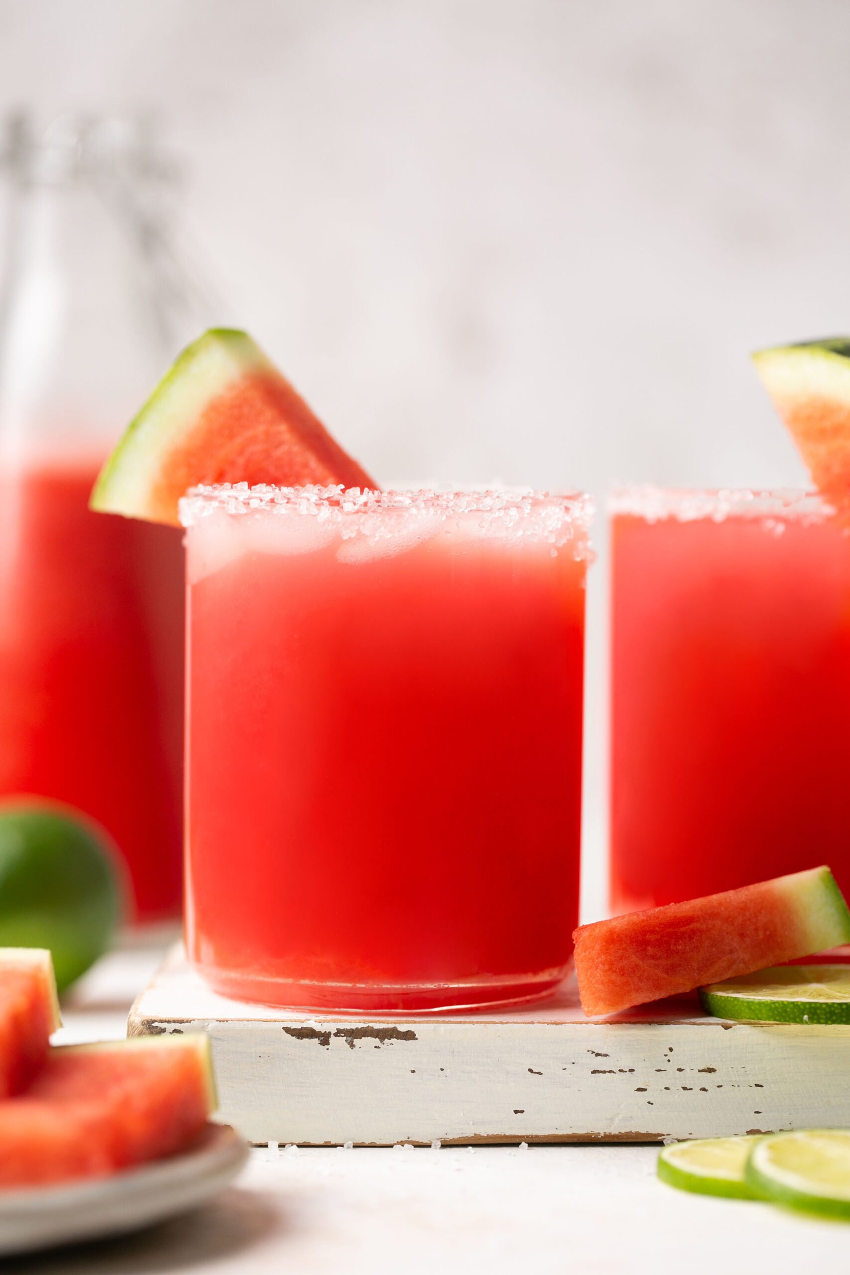 a fresh watermelon margarita in a salt-rimmed glass with a wedge of watermelon for garnish