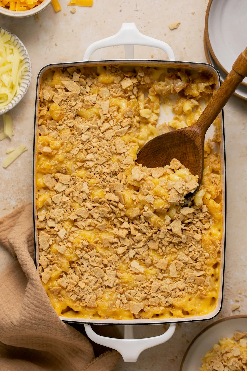 gluten free mac and cheese in a casserole dish with a wooden spoon