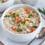 Creamy chicken and wild rice soup in a bowl on a plate with a spoon
