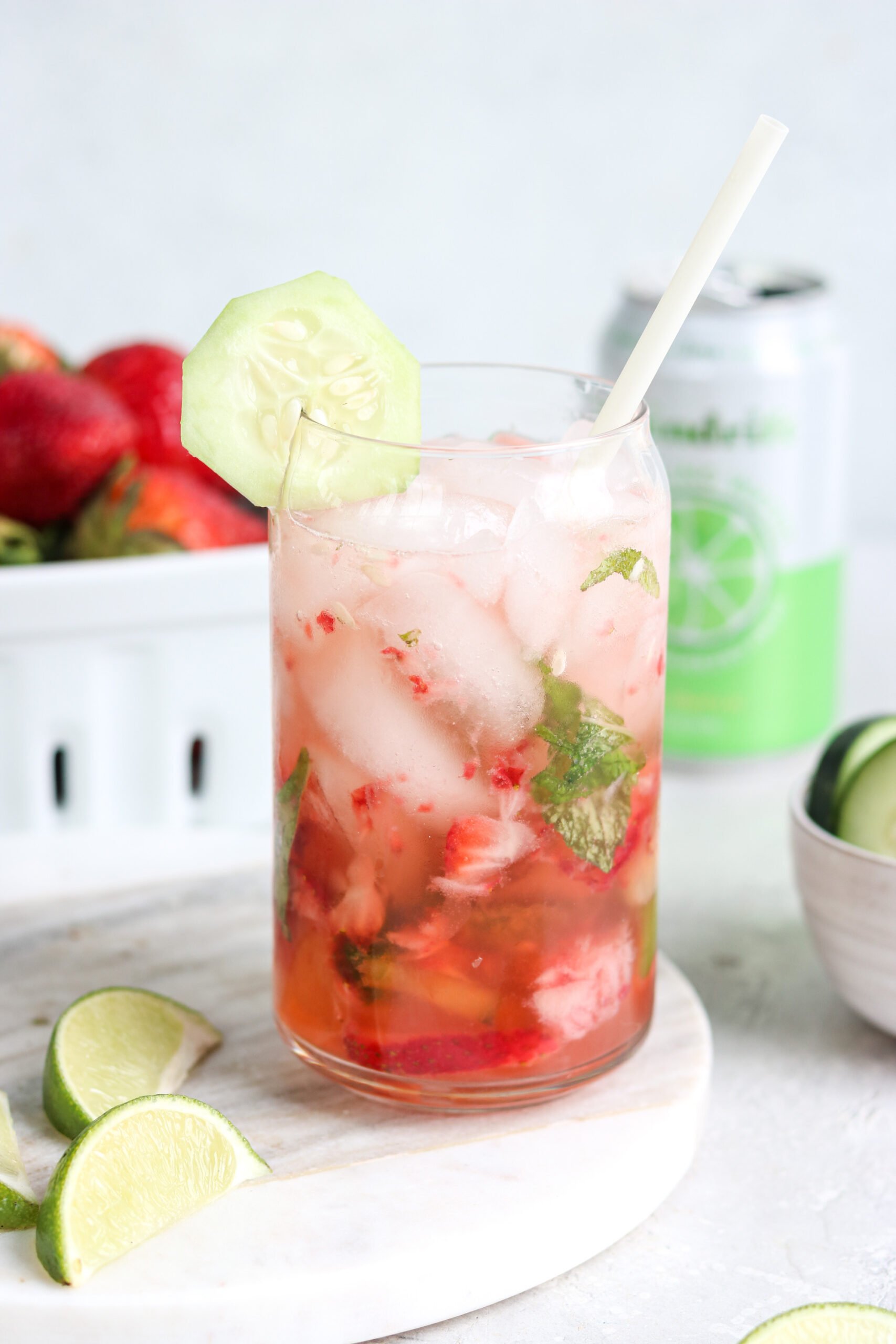 mojito mocktail with strawberries and cucumbers in a glass with a straw