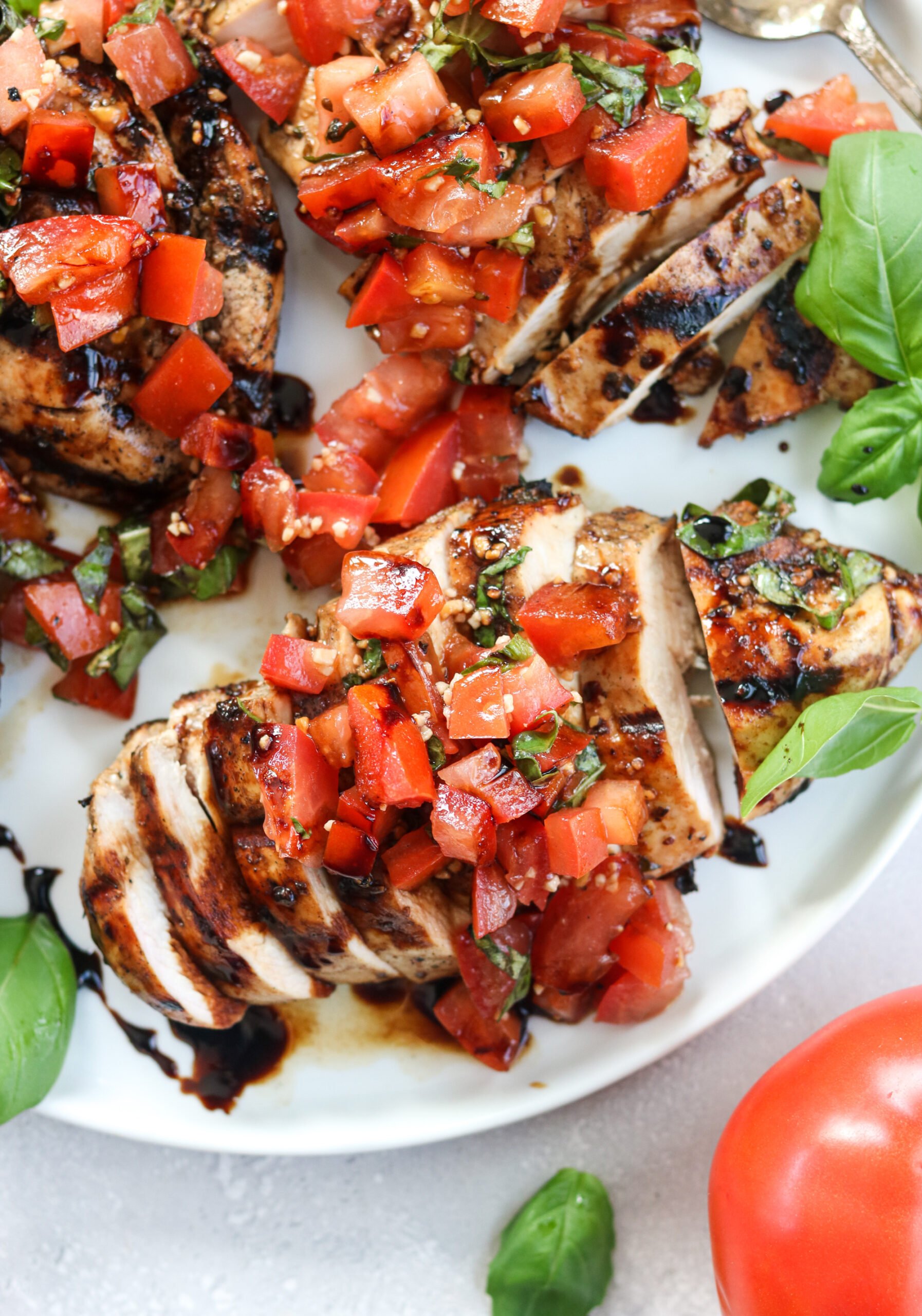 Grilled Chicken with red tomatoes on a white plate