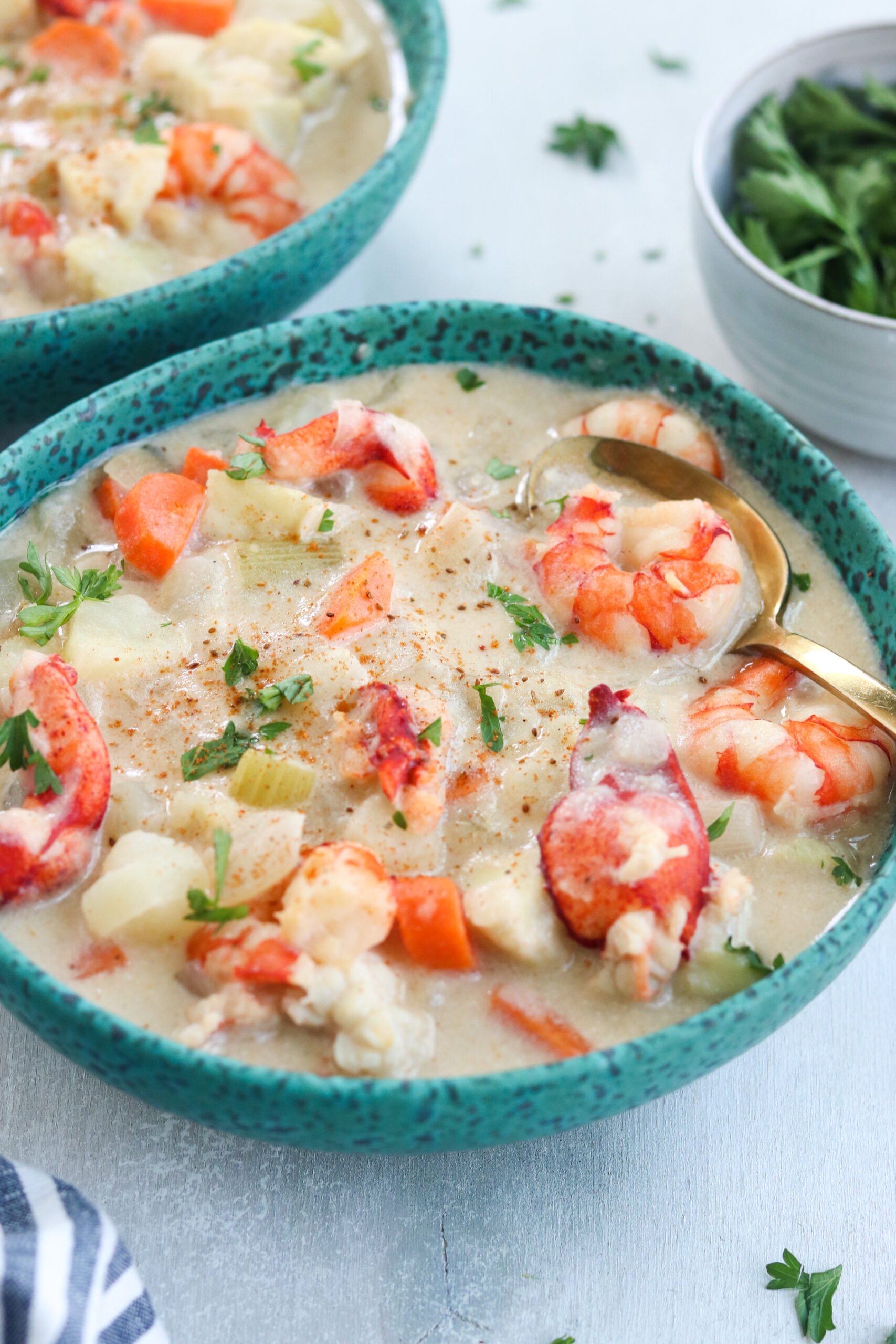 a bowl of Paleo Seafood Chowder with golden spoon