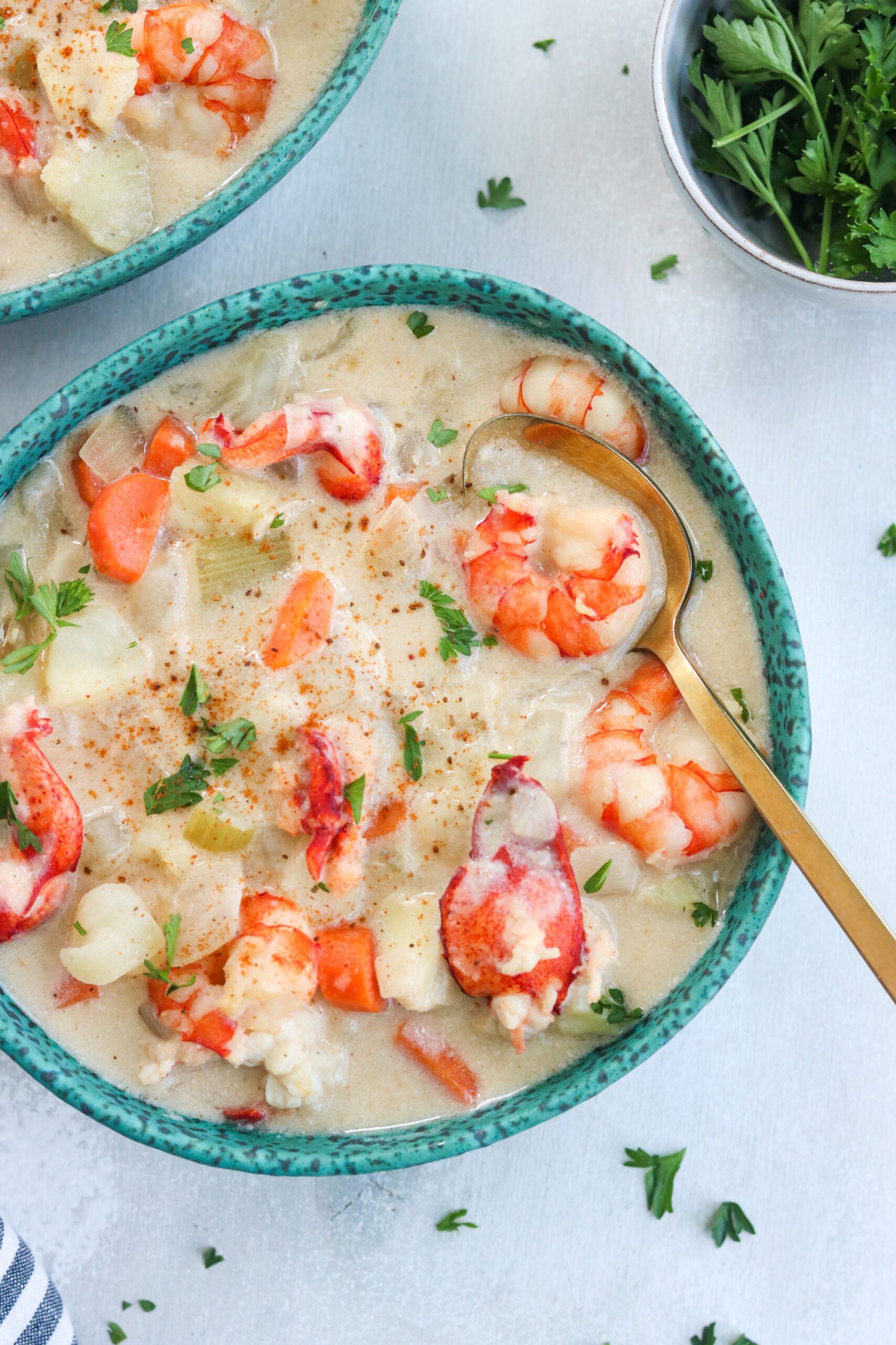 a bowl of Paleo Seafood Chowder with golden spoon