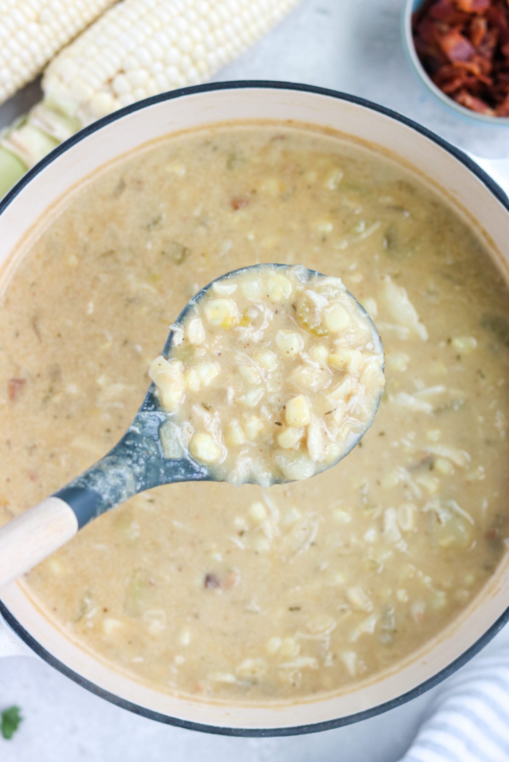 dairy free crab and corn chowder on a bowl surrounded by raw ingredients