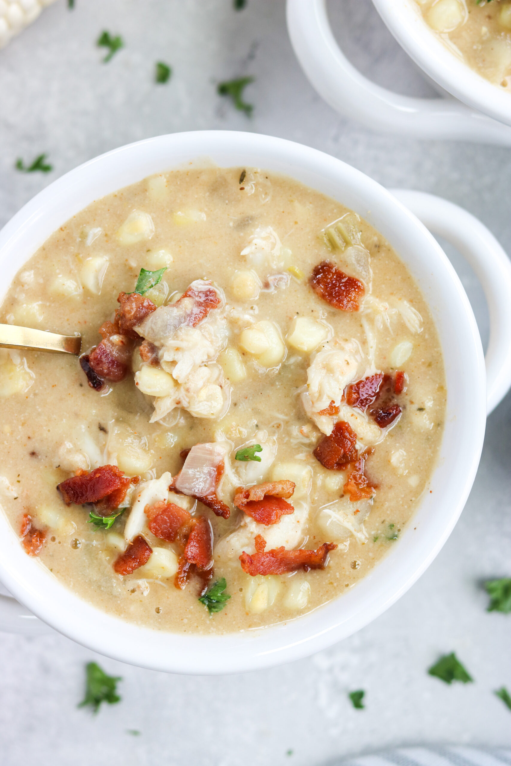 a bowl of dairy free crab and corn chowder with golden spoon 