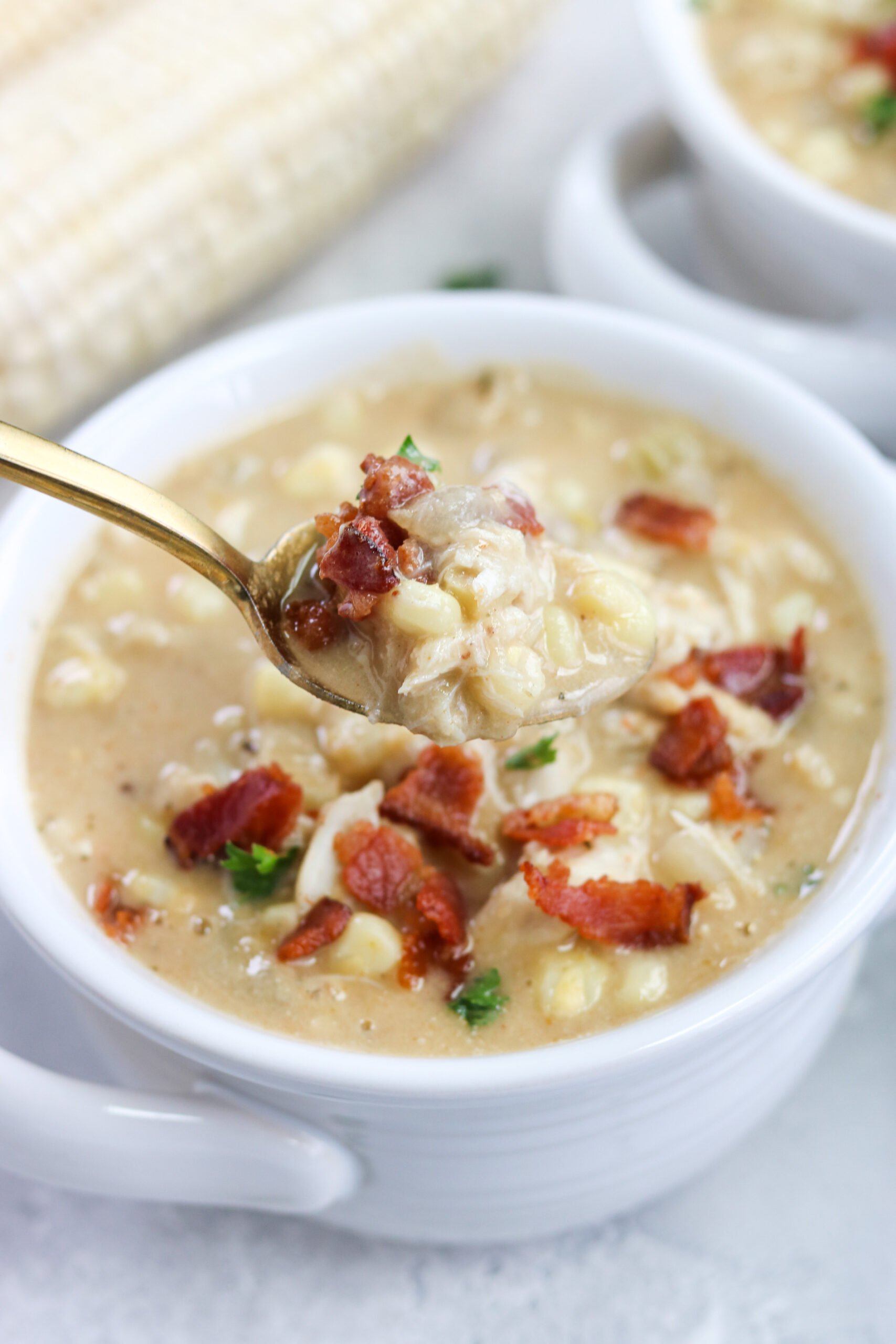 a person using a spoon and getting a part of the Dairy Free Crab and Corn Chowder