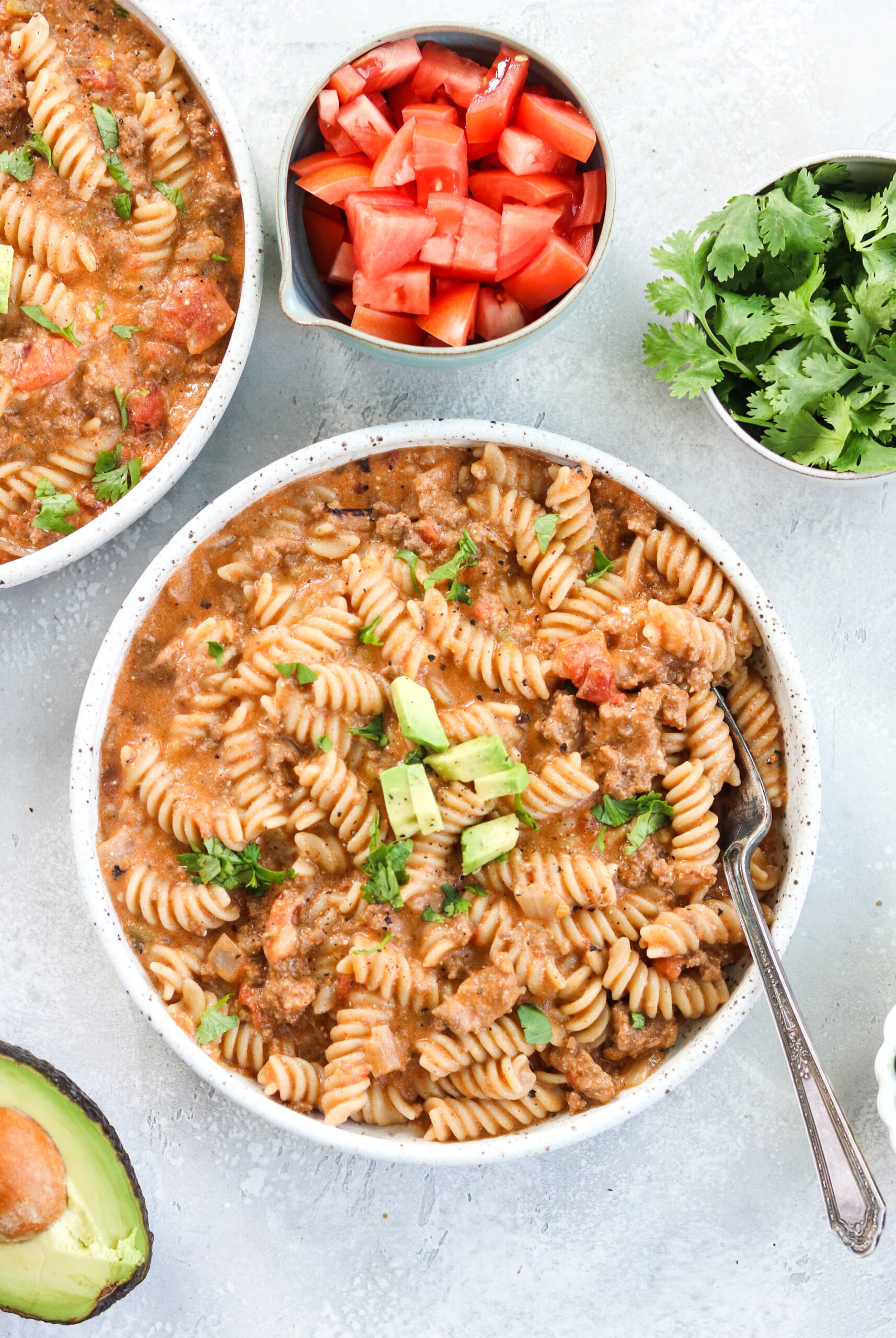 top view of pasta, tomatoes, avocado, and mint 