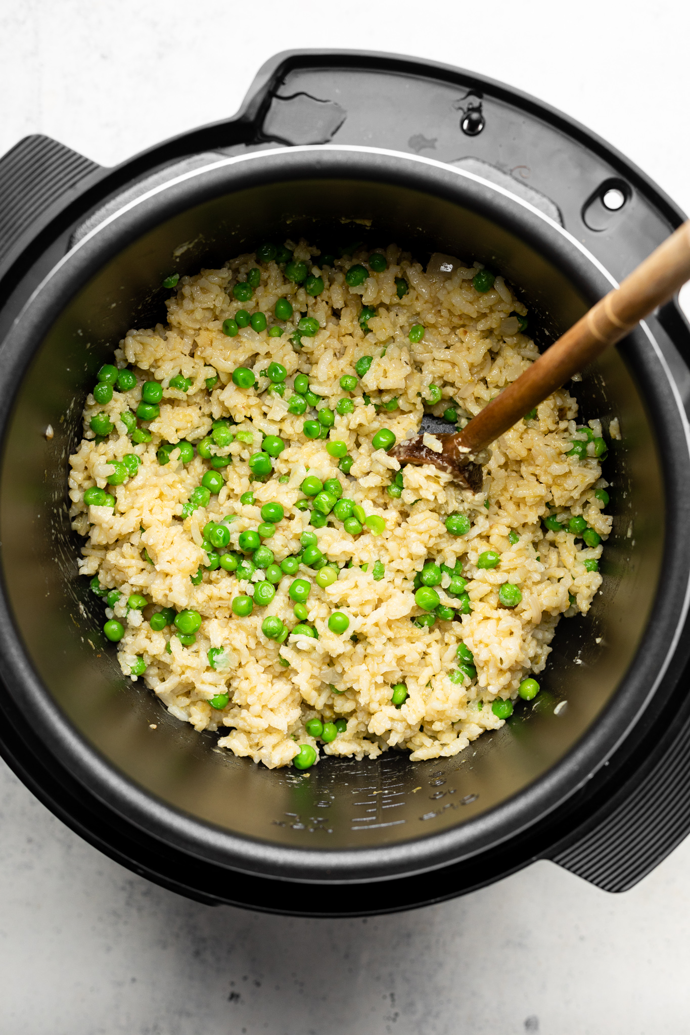 rice and peas in an instant pot with a wooden spoon