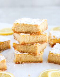 gluten free lemon bars stacked with lemon slices on the side