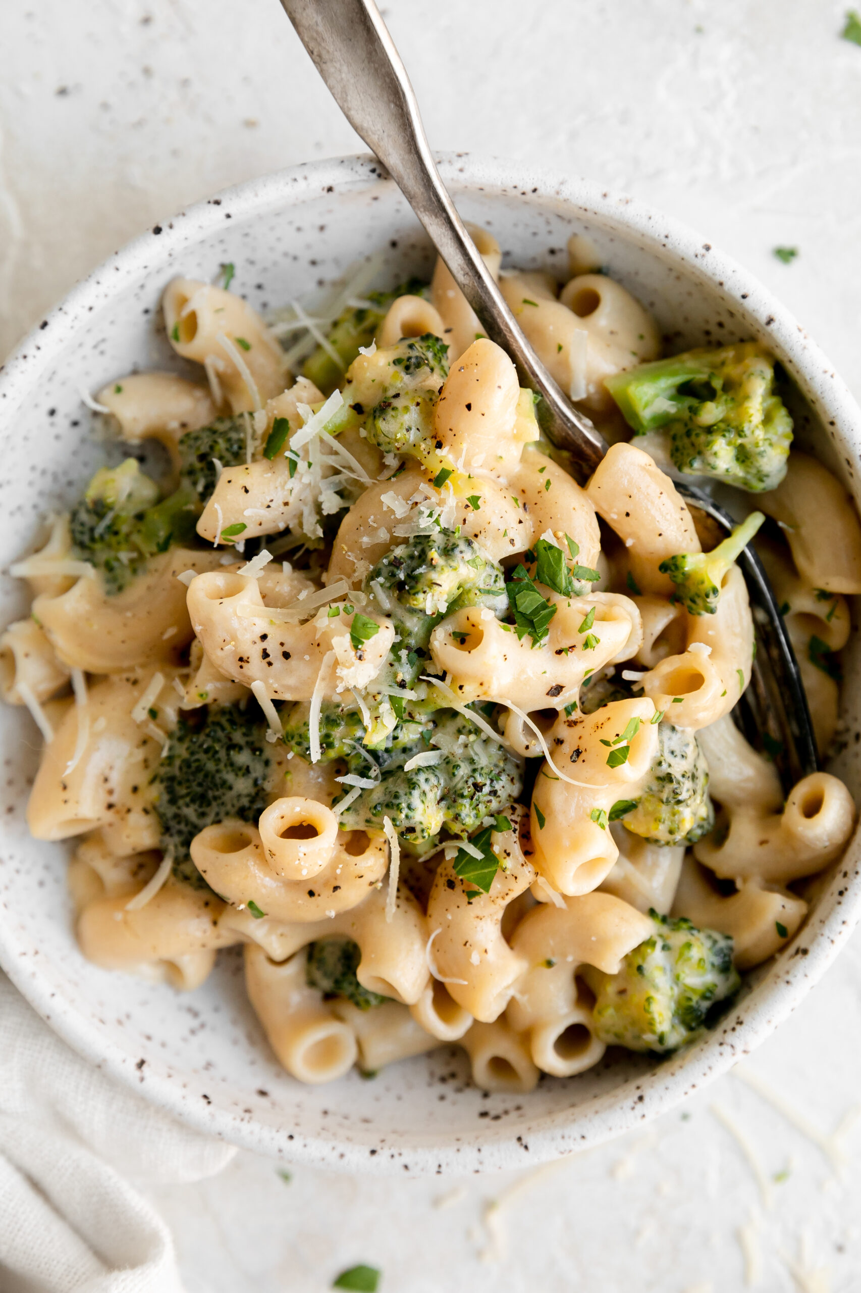 a closeup of a bowl of mac and cheese with broccoli