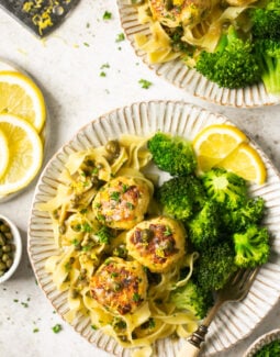 gluten free chicken piccata meatballs with pasta and broccoli and lemon on 2 plates