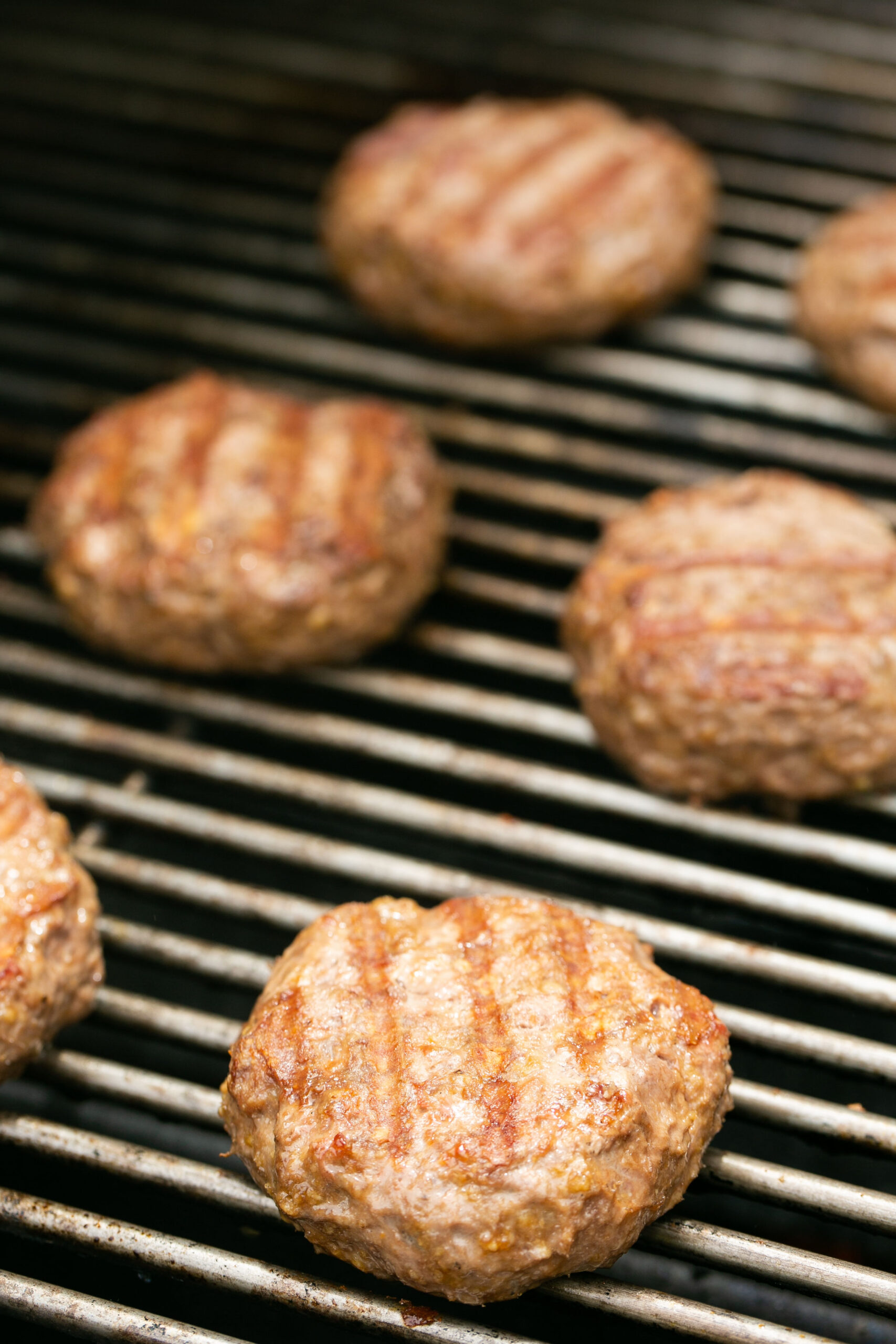a photo of burger patties grilling on a bbq
