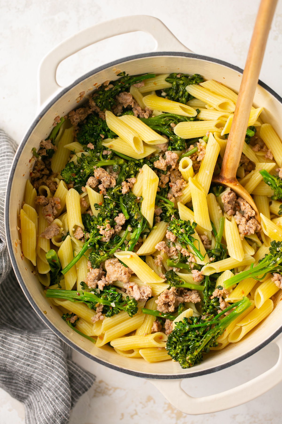 a white dutch oven with pasta and broccoli