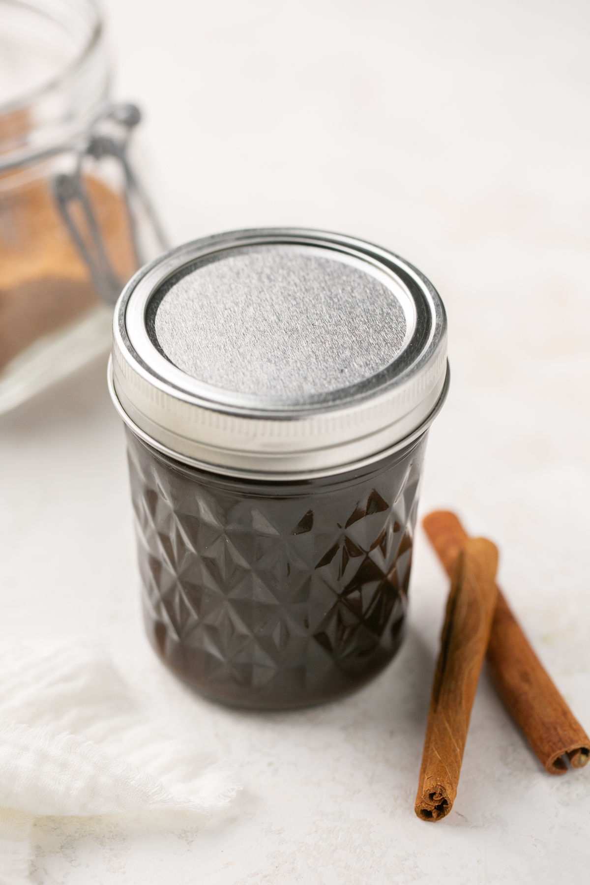 a closeup of brown sugar syrup in a mason jar with a silver lid. 