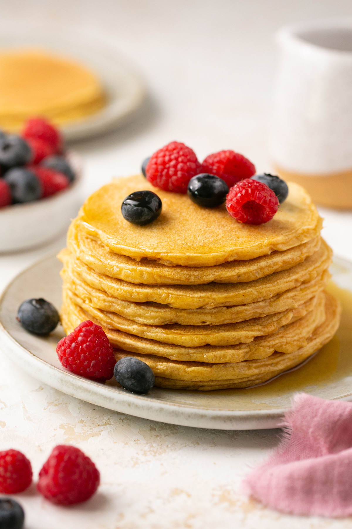 protein pancakes stacked on a plate with berries
