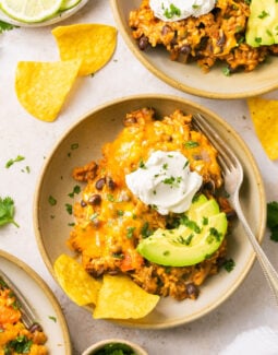 loaded taco skillet in a bowl with sour cream, avocado, and chips