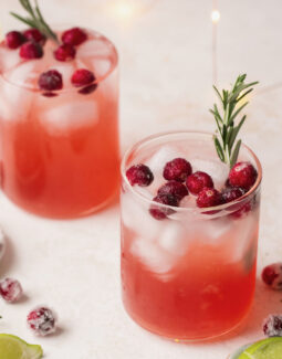 mistletoe martini with vodka and cranberry juice topped with cranberries and rosemary