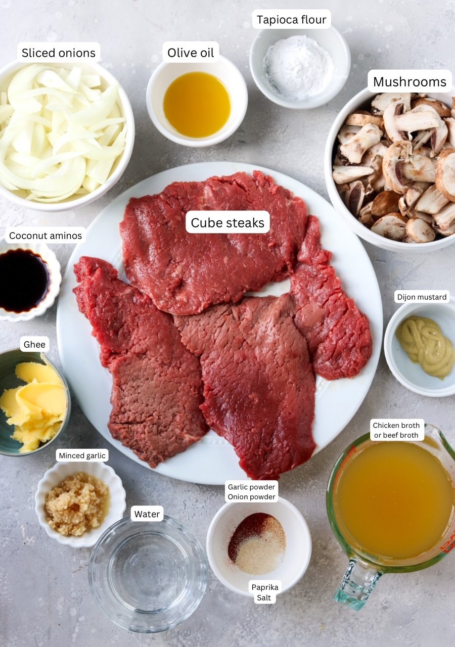Ingredients for a cube steak recipe portioned out in nesting bowls and plates