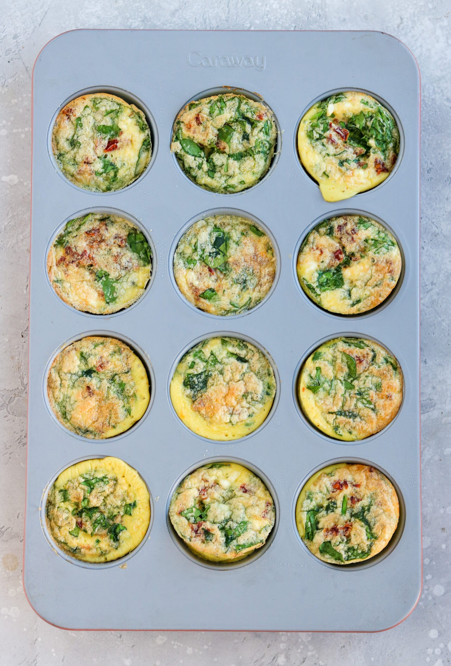 12 egg bites cooked in a gray muffin tin