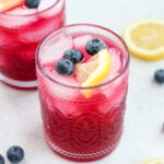 lemon blueberry mocktail in a glass topped with a lemon slice and blueberries