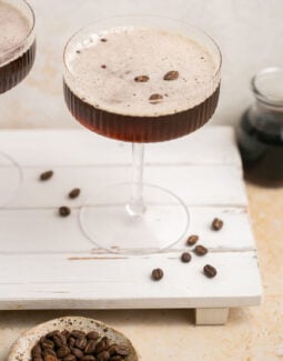espresso martini on a palate board with espresso beans around it