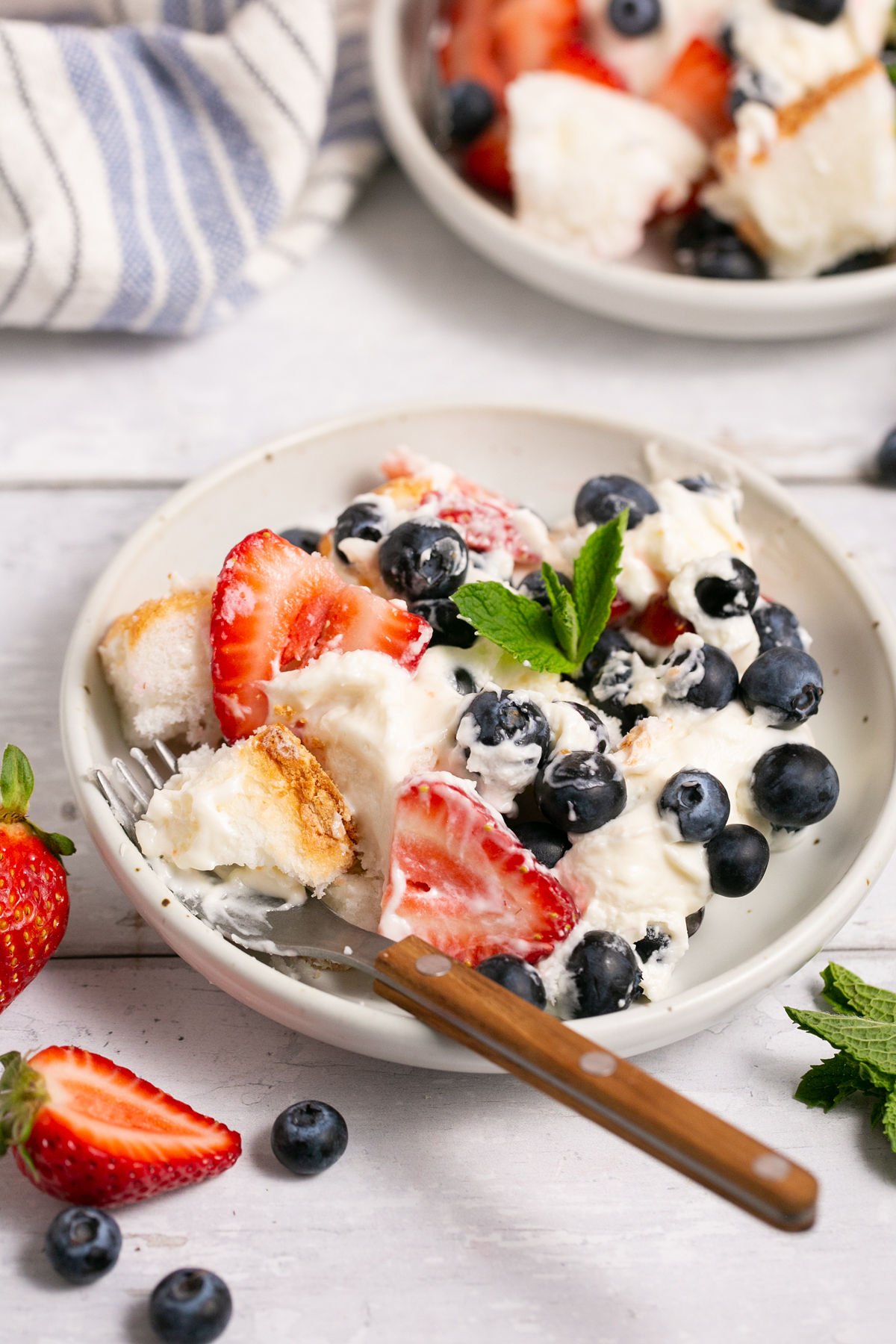 gluten free berry angel food cake trifle in a bowl with a spoon