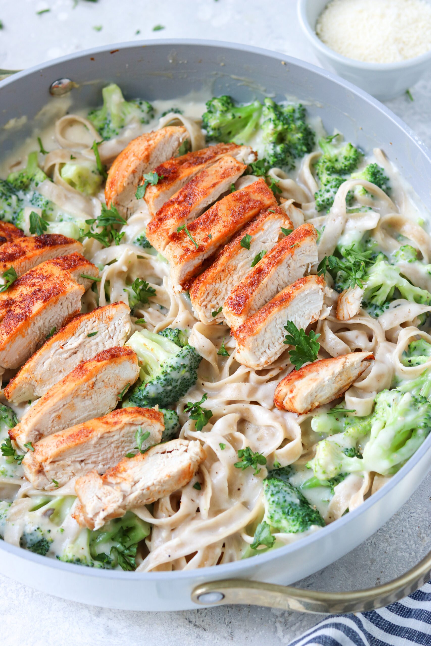 chicken and broccoli with alfredo sauce and gluten free tagliatelle pasta in a skillet