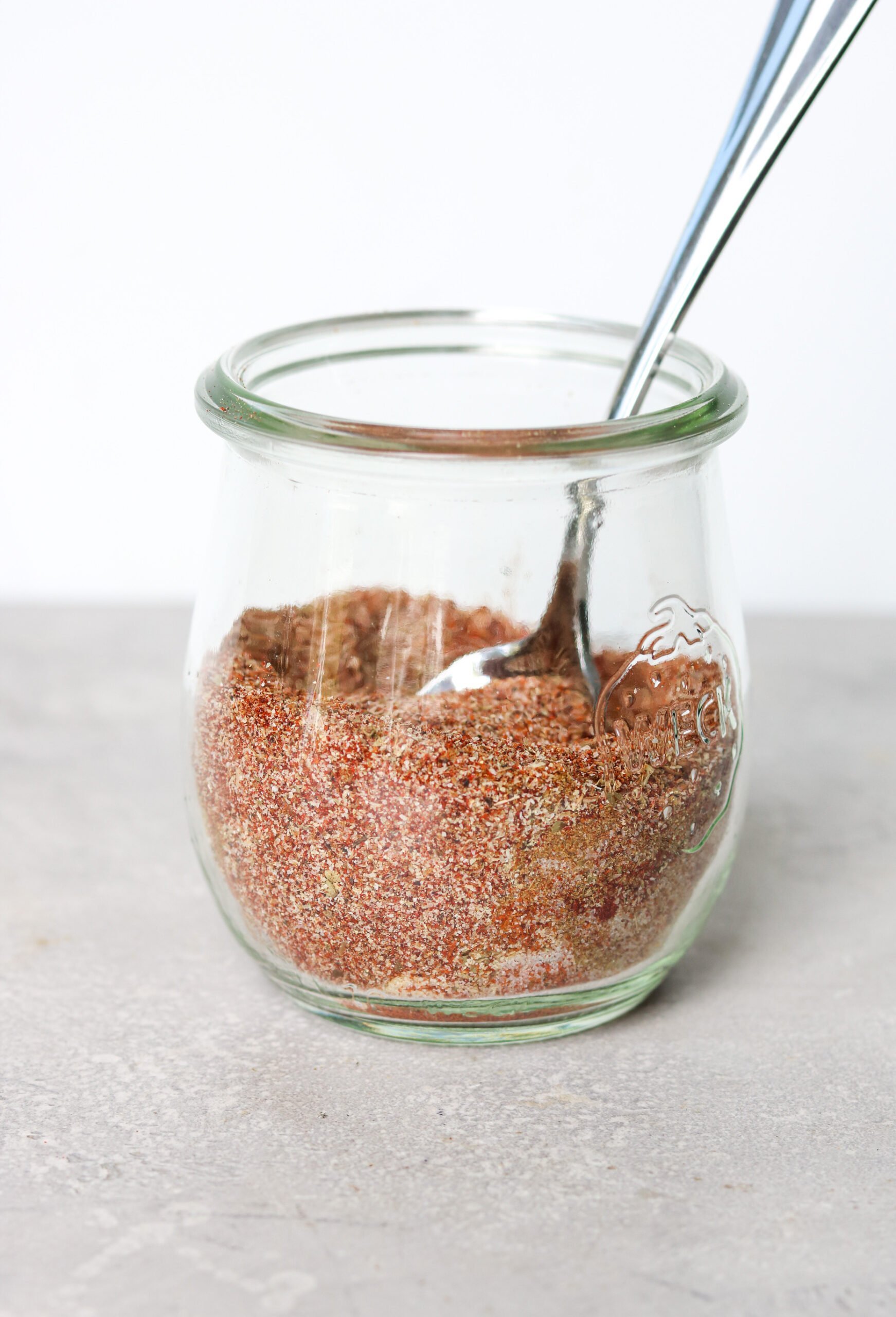 spices in a glass jar with a spoon