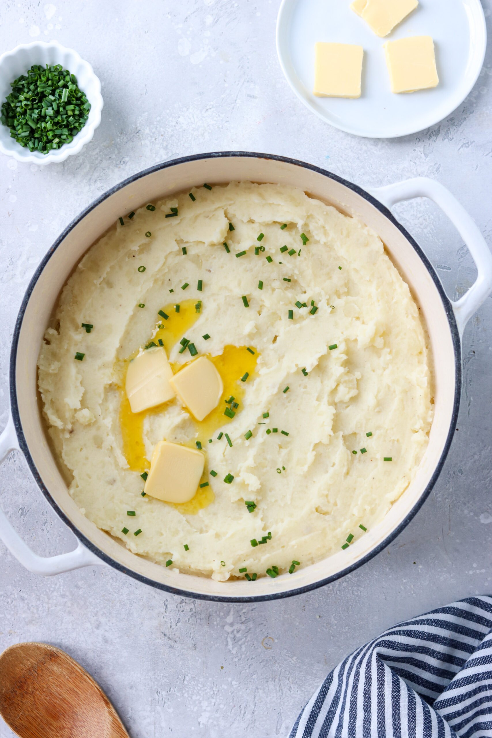 gluten free mashed potatoes in a pot topped with chives and melting butter