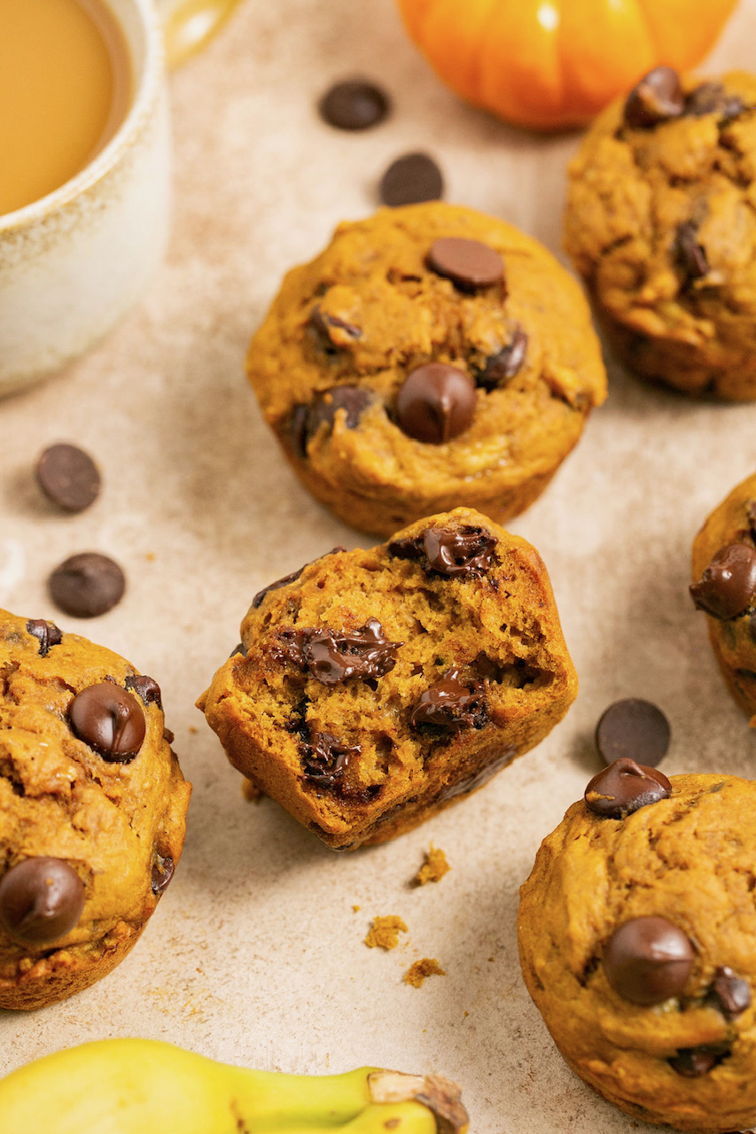 an up close photo of the middle of a pumpkin banana muffin showing the melted chocolate chips and fluffy middle. 