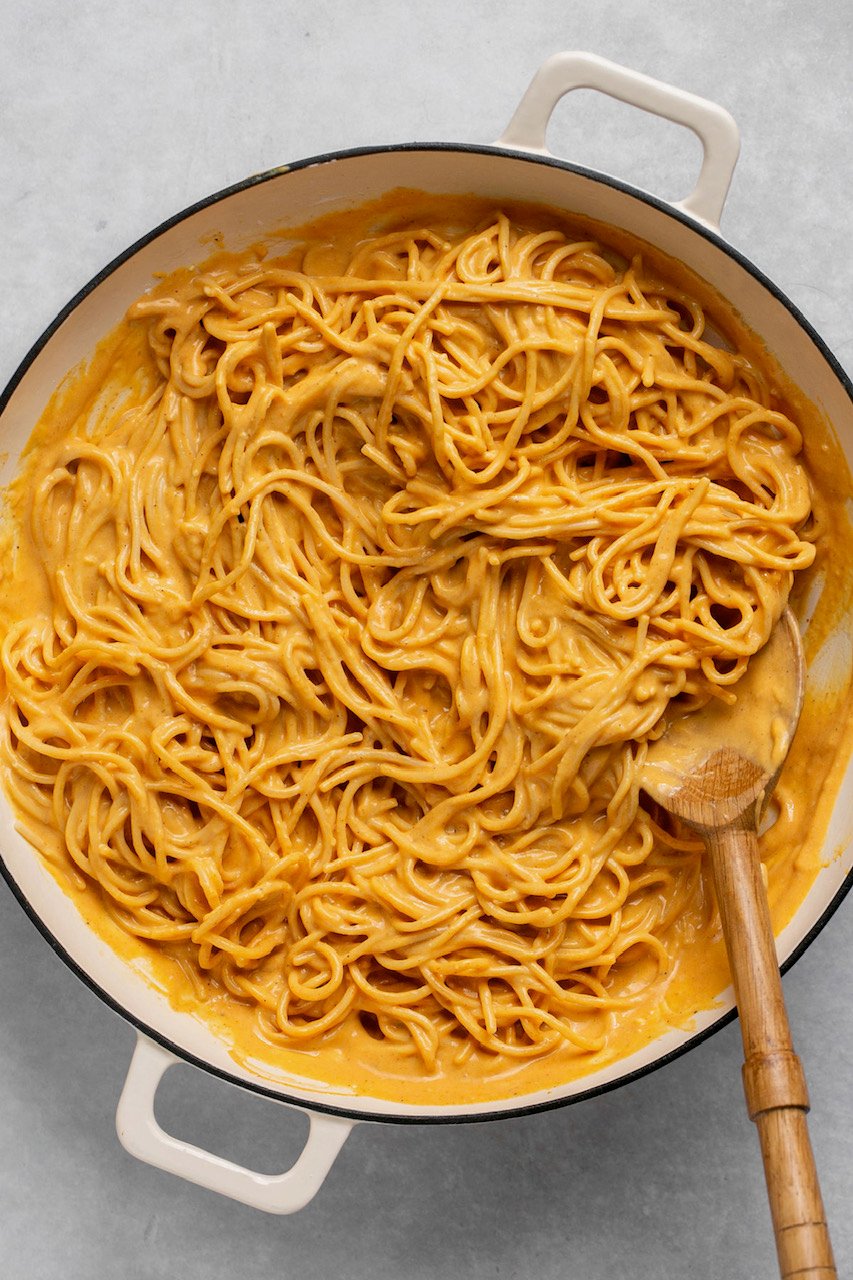 pumpkin sauce with gluten free spaghetti in a pot with wooden spoon