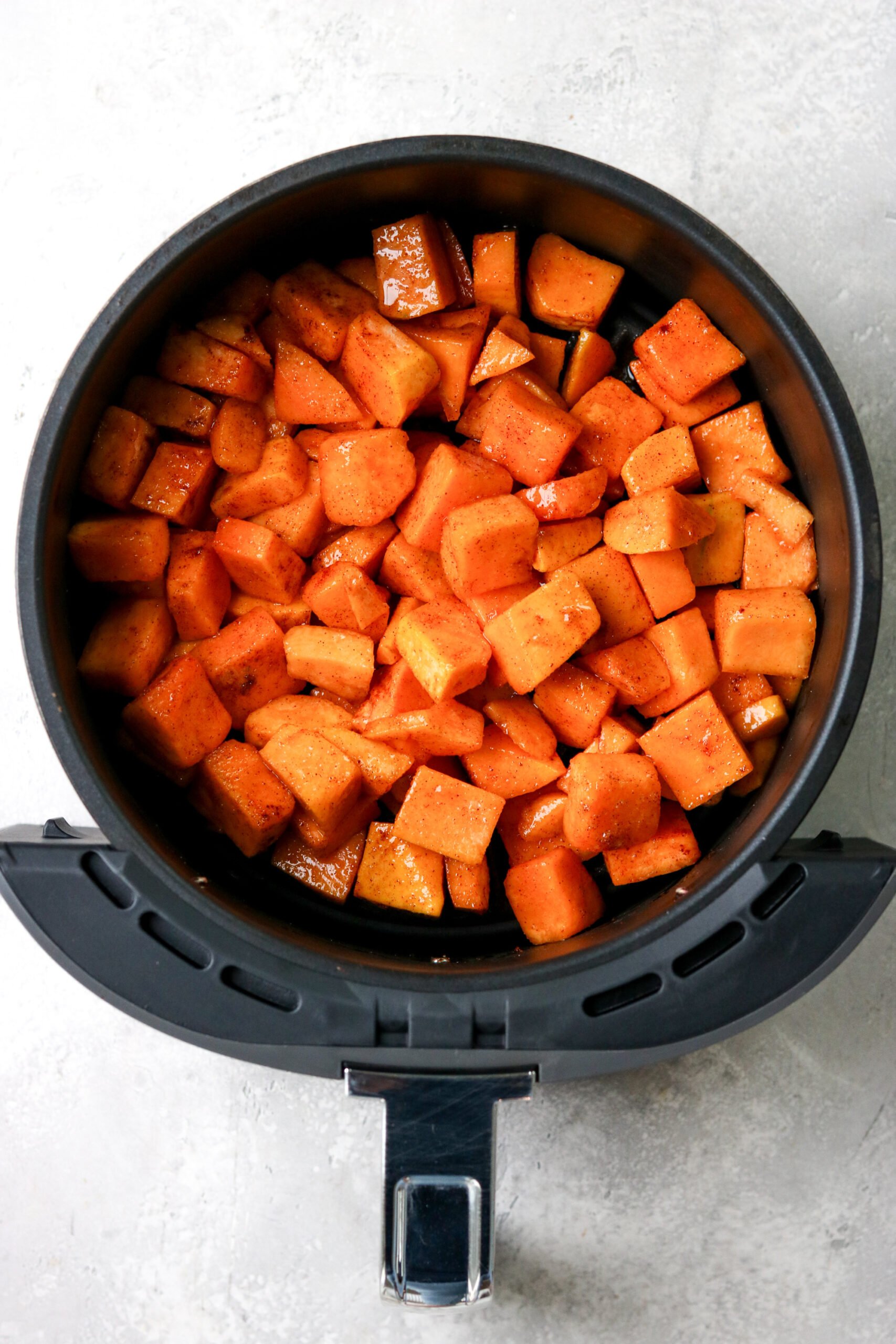 uncooked butternut squash cubes in an air fryer 