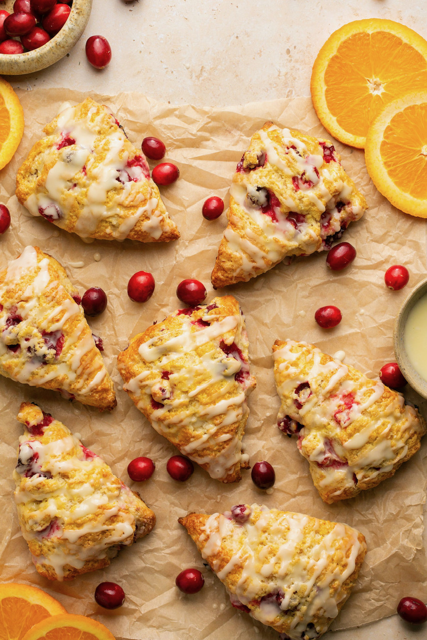 7 scones on parchment paper with cranberries and orange