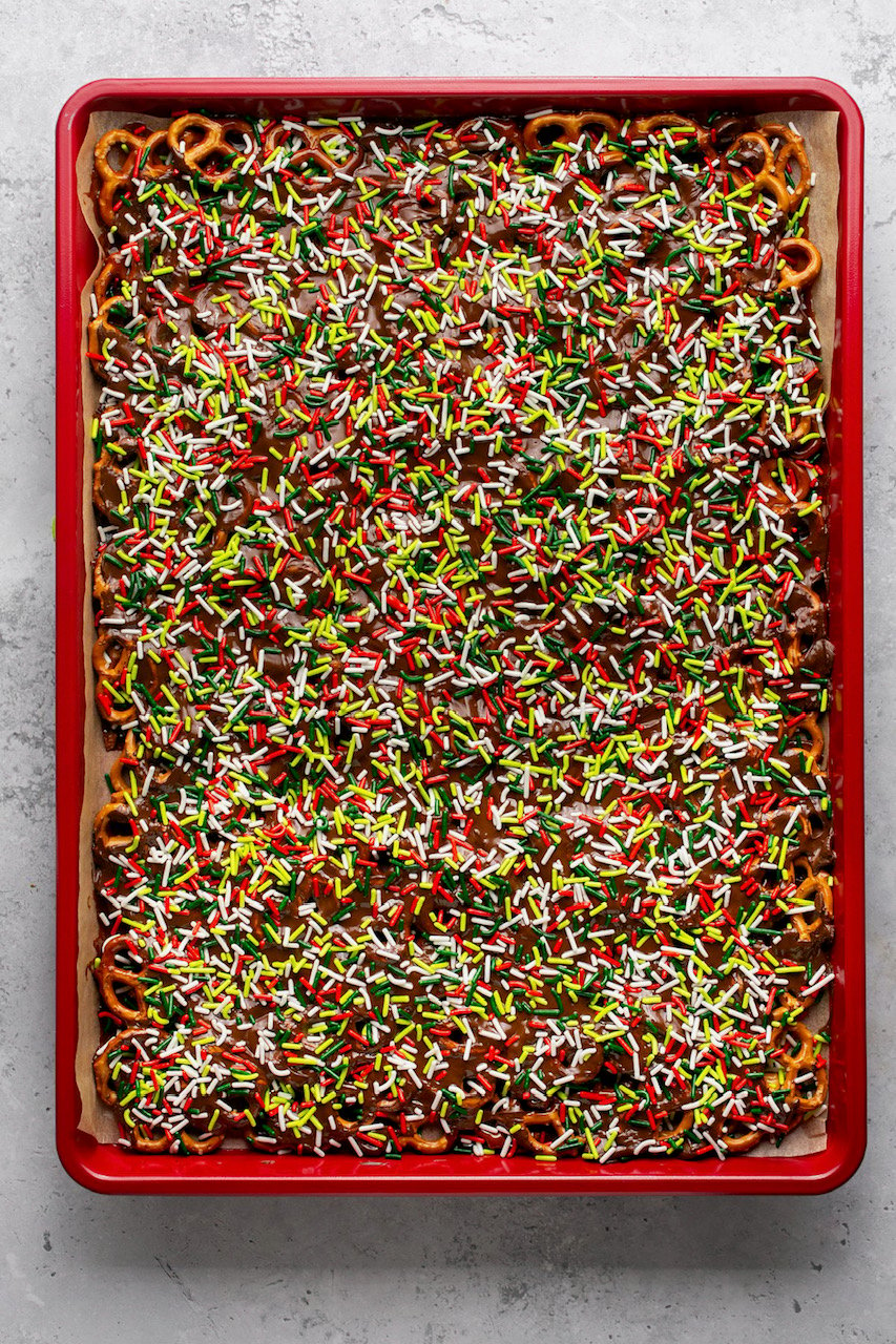 a pan of caramel and chocolate covered pretzels with sprinkles