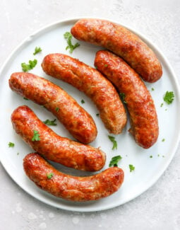 air fried Italian sausage on a white plate topped with parsley