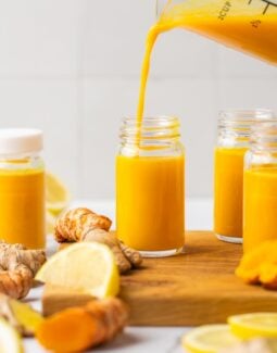 lemon ginger turmeric pineapple shot being poured into a shot glass