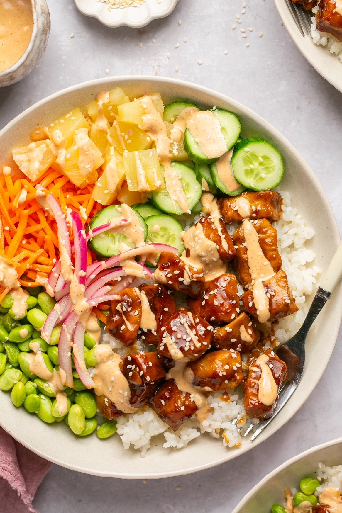 chicken poke bowls with toppings and spicy mayo in a bowl