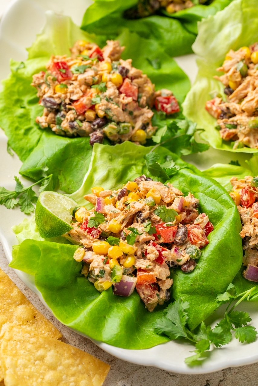 an up close photo of tuna salad on a lettuce cup with a lime wedge. 