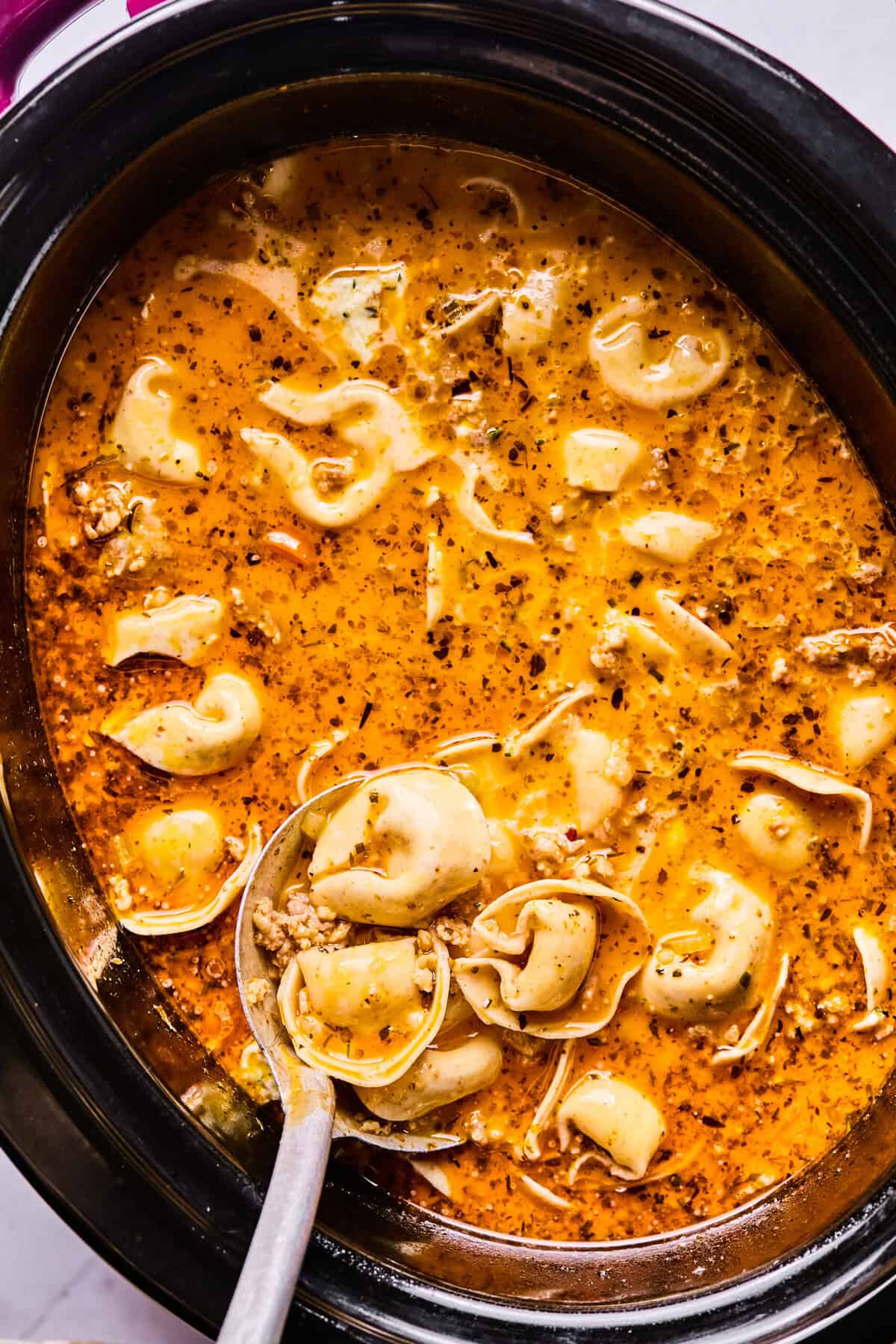 cooked tortellini resting inside the slow cooker 